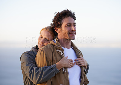 Buy stock photo A cropped shot of a happy couple standing together affectionately outdoors