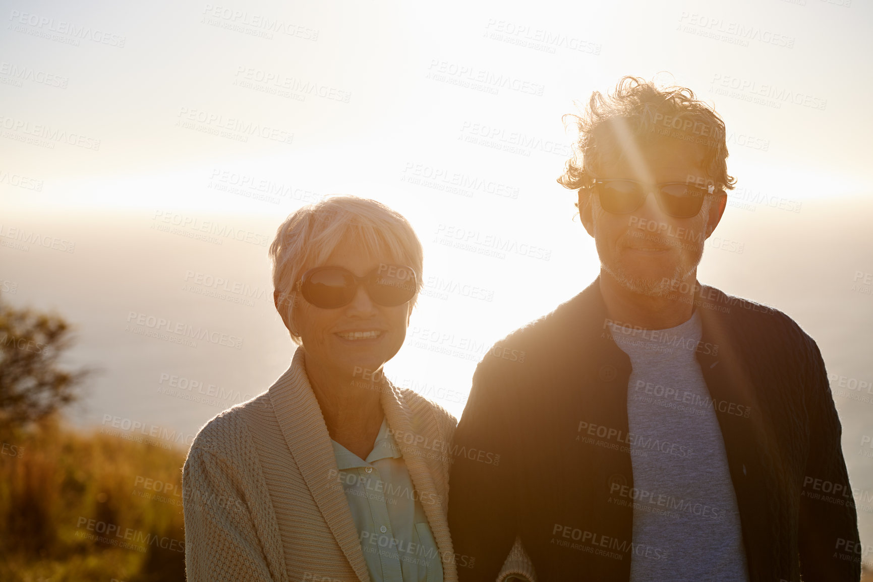 Buy stock photo Cropped view of a senior couple standing on a hillside together
