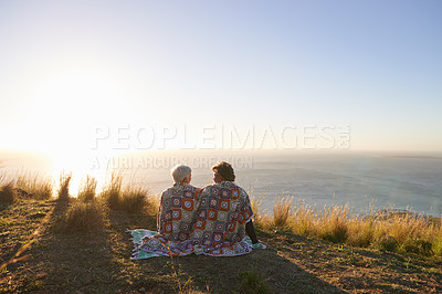 Buy stock photo View of a senior couple sitting on a hillside together
