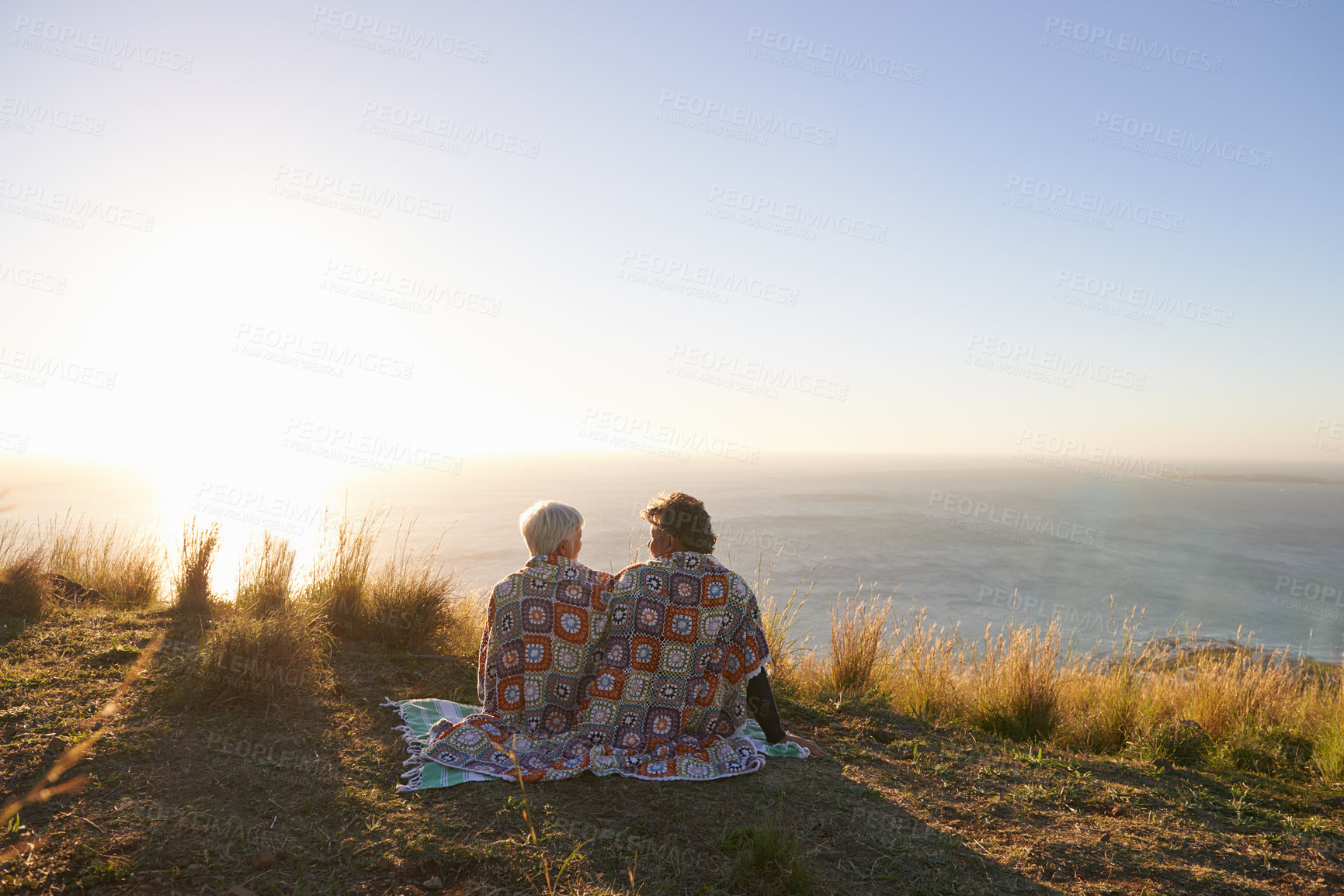 Buy stock photo View of a senior couple sitting on a hillside together