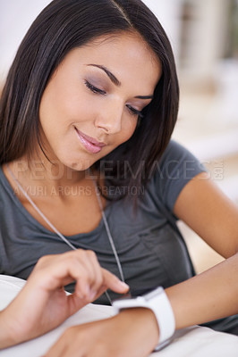 Buy stock photo Shot of an attractive woman looking at her smartwatch
