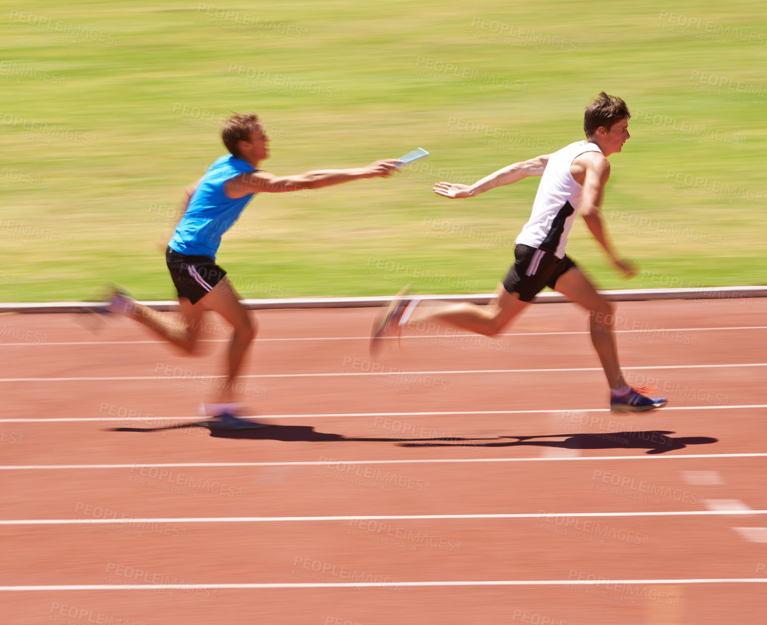 Buy stock photo Shot of two young athletes running in a relay race