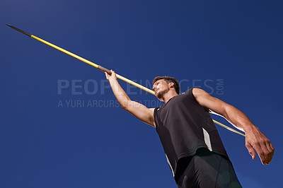 Buy stock photo Shot of a lone man throwing a javelin outside