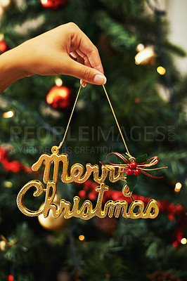 Buy stock photo Merry Christmas sign, hand of woman and decoration for Christmas tree in home. Xmas, holiday or vacation and female holding golden ornaments or decorations for festive party or celebration in house.