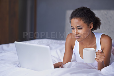 Buy stock photo Cropped shot of a young woman enjoying a cup of coffee while working on a laptop