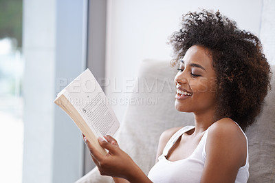 Buy stock photo Happy, black woman and reading with book on couch for novel, story or literature in living room at home. African female person with smile for information, news or interesting knowledge at the house