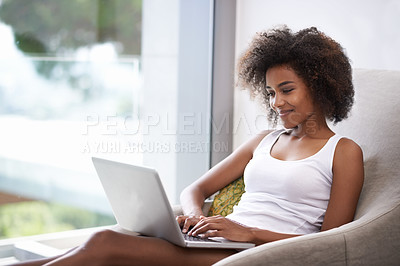 Buy stock photo Shot of a beautiful young woman in pajamas using a laptop