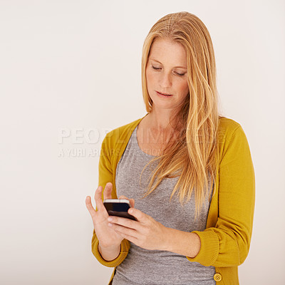 Buy stock photo Shot of a woman sending a text message on her mobile phone