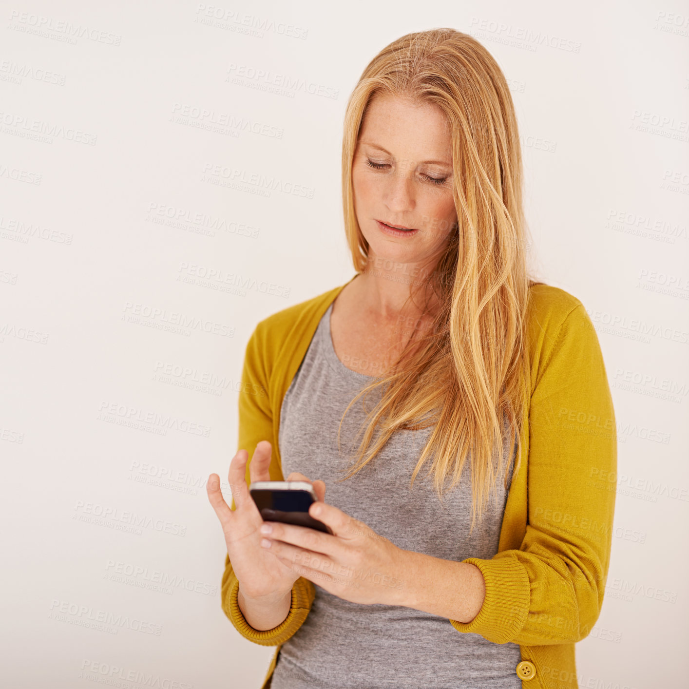 Buy stock photo Shot of a woman sending a text message on her mobile phone