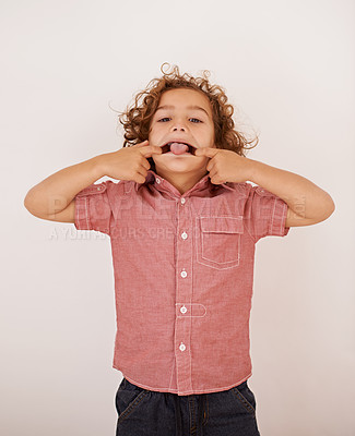 Buy stock photo Boy, kid and portrait in studio with tongue out for funny face, joke or games by white background. Child, mouth and comic gesture with fashion, playful and emoji with trendy style, shirt or clothes