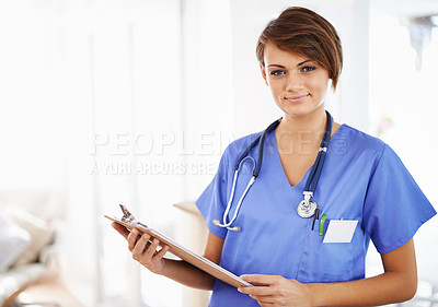 Buy stock photo Portrait of an attractive young doctor in scrubs holding a clipboard