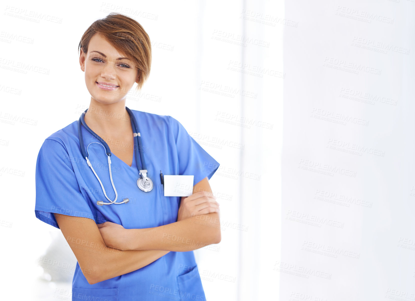 Buy stock photo Portrait of a confident young doctor wearing blue scrubs