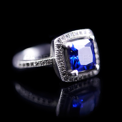 Buy stock photo Blue, silver and ring on a black background for luxury, expensive and present for engagement or marriage in studio. Jewelry, diamonds and crystal rock in closeup with shine and reflection for a gift