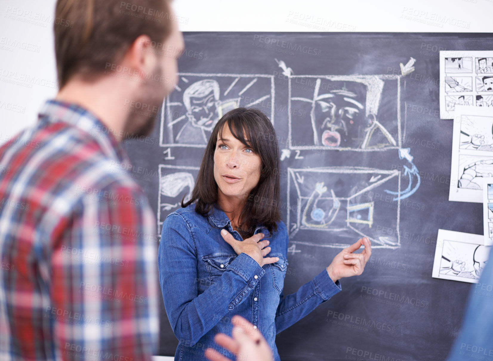 Buy stock photo Shot of two coworkers planning a storyboard on a blackboard