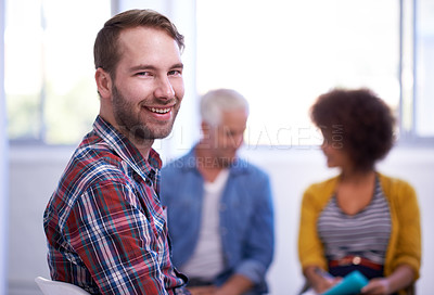 Buy stock photo Portrait of a handsome young man in a meeting with his coworkers