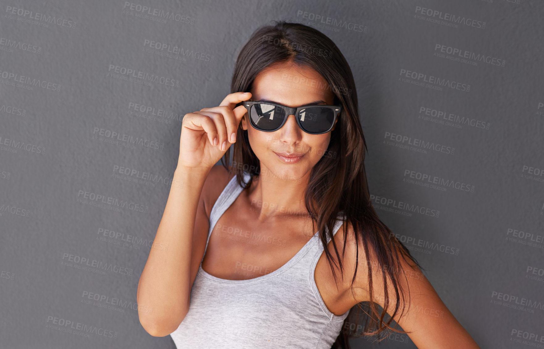 Buy stock photo Shot of a beautiful young woman wearing sunglasses being flirty