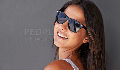 Buy stock photo Shot of an attractive young woman wearing sunglasses