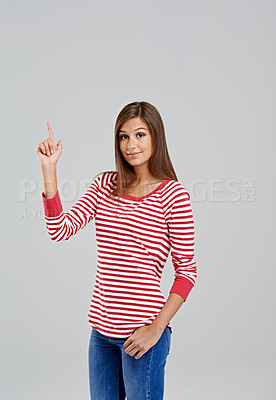 Buy stock photo Pointing, mockup and portrait of woman for fashion, style and trendy with cool outfit isolated on gray background. Female person, hand and lady with stripe shirt, blue jeans and garments in studio