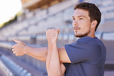 Buy stock photo Fitness, arms and man stretching in stadium for race, marathon or competition training for health. Sports, energy and male runner athlete with warm up exercise for running cardio workout on track.