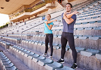 Buy stock photo Fitness, arms and couple stretching at stadium for race, marathon or competition training for health. Sports, energy and runner athletes with warm up exercise for running cardio workout on track.