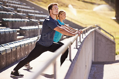 Buy stock photo Sports, legs and couple stretching in stadium for race, marathon or competition training for health. Fitness, wellness and runner athletes with warm up exercise for running cardio workout on track.