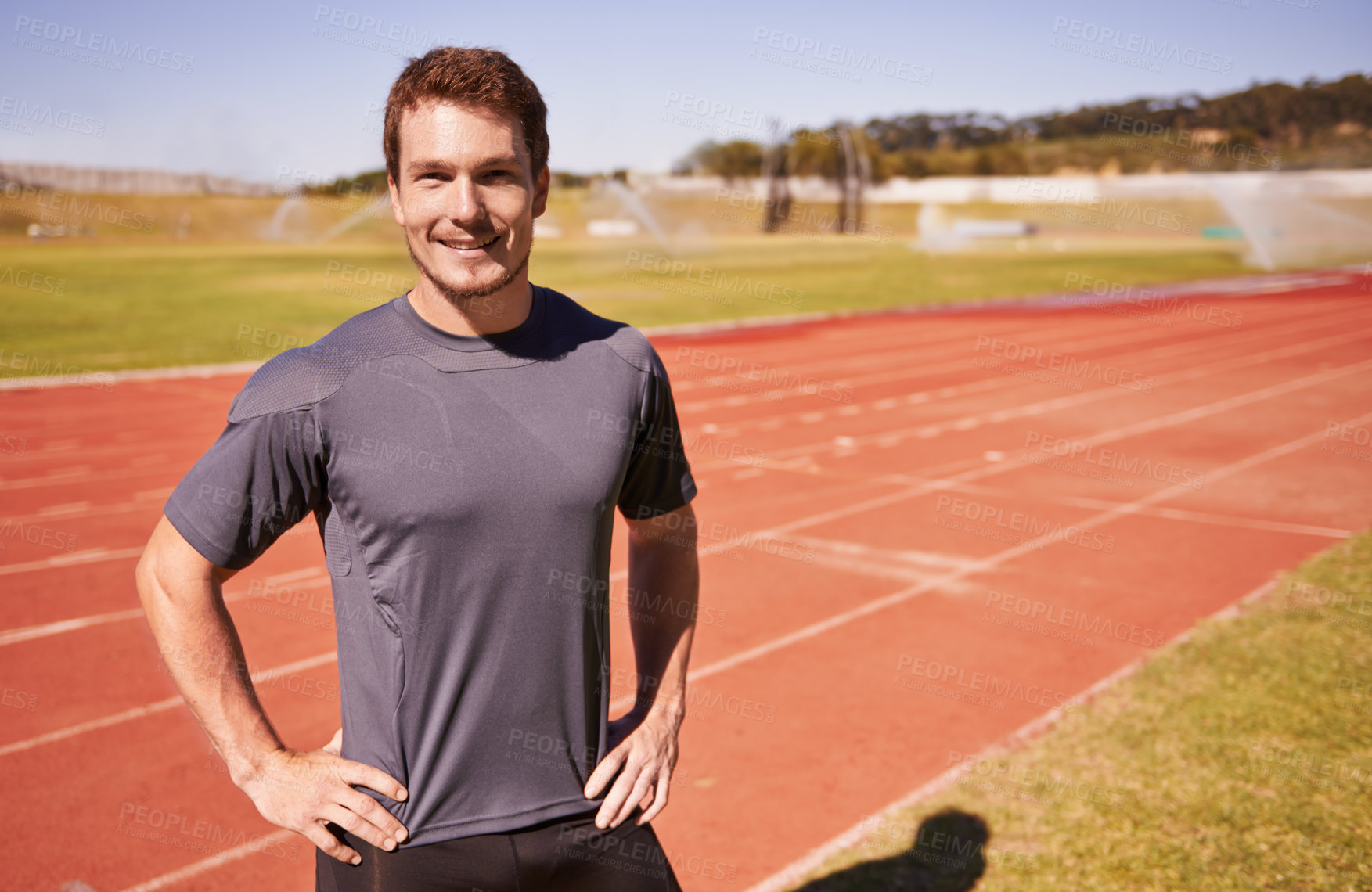 Buy stock photo Shot of a handsome young runner out on the track