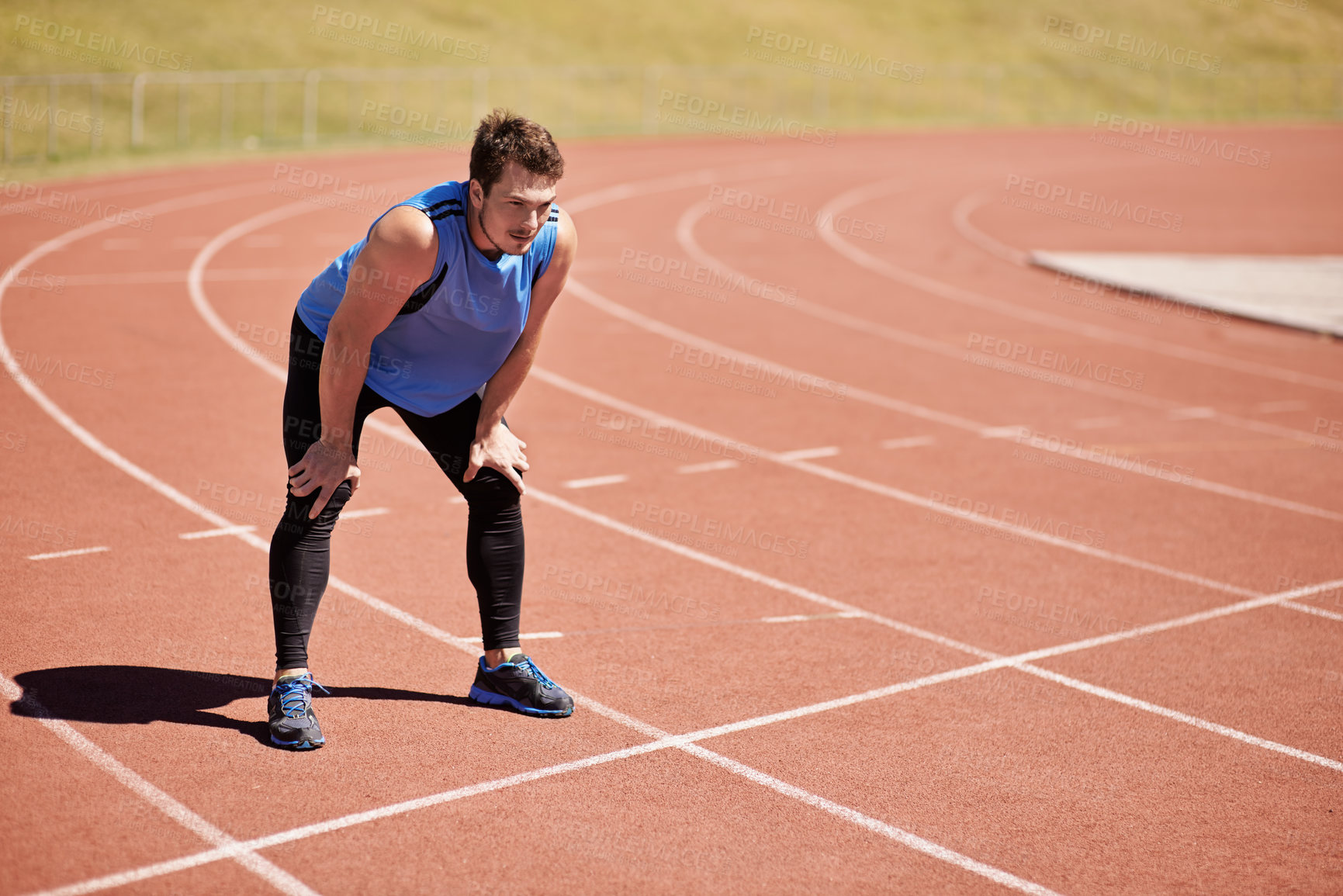 Buy stock photo Shot of a handsome young runner out on the track