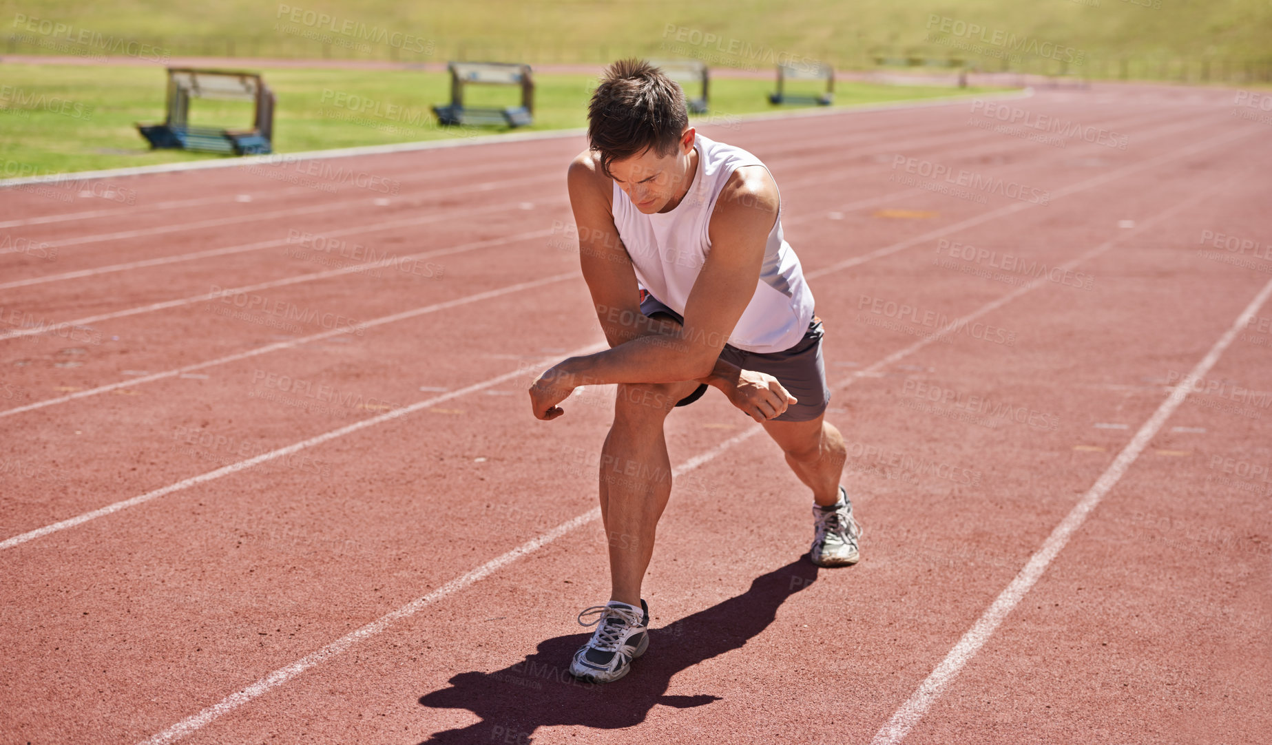 Buy stock photo Fitness, running and stretching with athlete man getting ready on track for sports, race or competition. Exercise, training and warm up with confident young person at stadium or venue for event