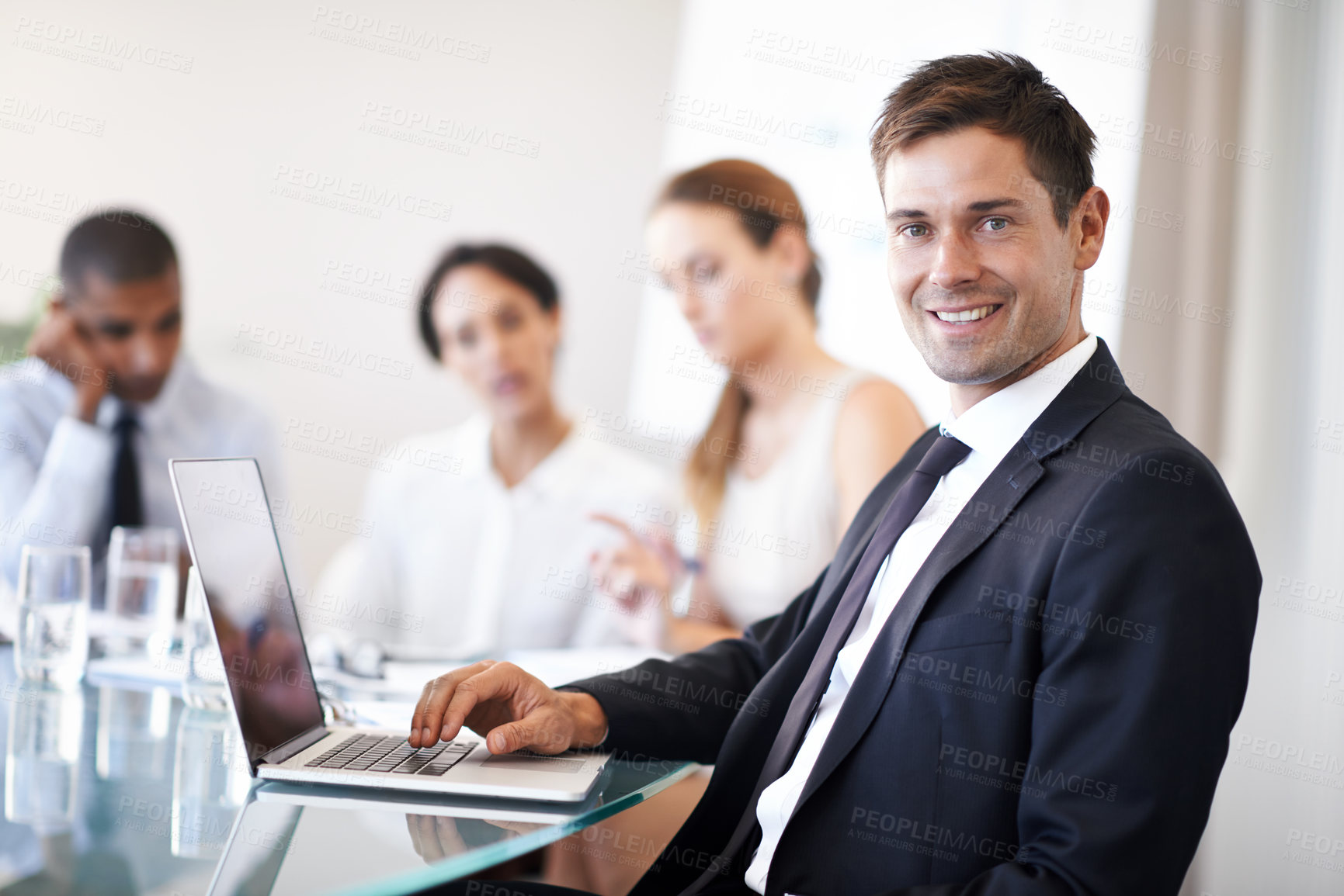 Buy stock photo Portrait of a happy businessman using a laptop during a meeting