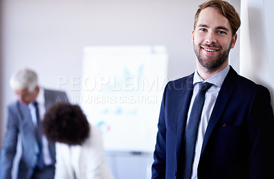 Buy stock photo Cropped view of a young businessman smiling while standing in a meeting