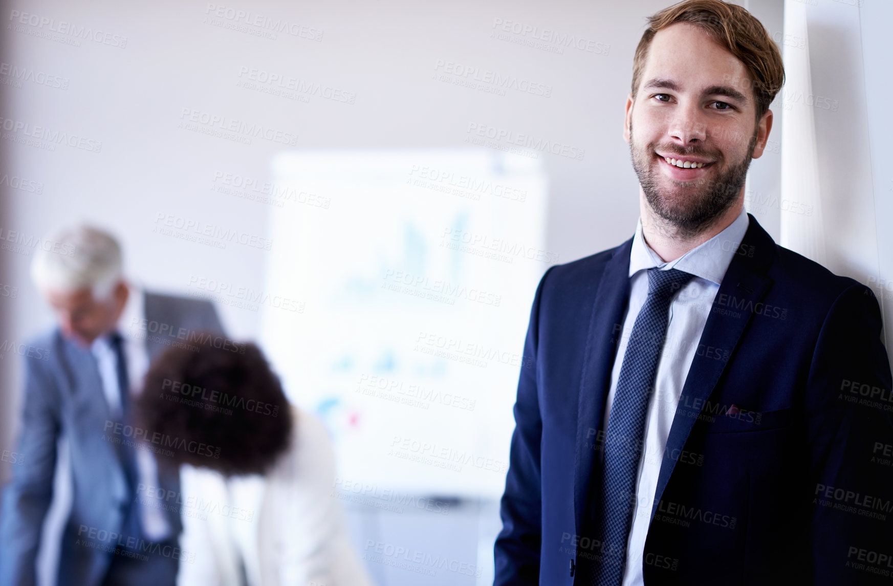 Buy stock photo Cropped view of a young businessman smiling while standing in a meeting