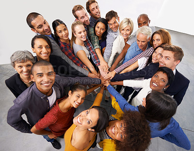Buy stock photo Shot of a diverse group of business people joining their hands in a symbol of unity