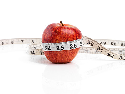 Buy stock photo Apple, food and tape measure with red fruit in studio isolated on white background for diet, health or nutrition. Size, vitamins and minerals with organic produce for wellness, detox or weightloss