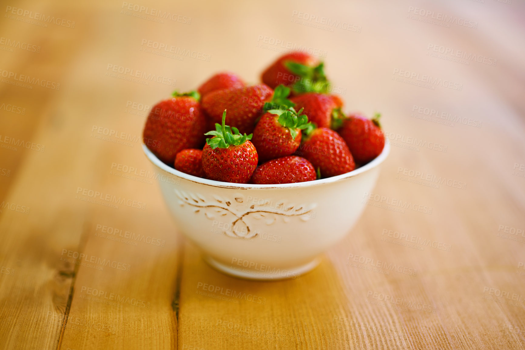 Buy stock photo Wellness, health and strawberry bowl in kitchen of home, on wooden counter top for diet or nutrition. Food, fruit and lose weight with berries on surface in apartment for detox, minerals or vitamins