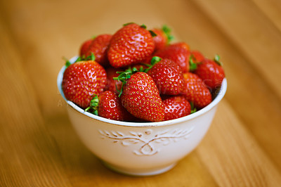 Buy stock photo Strawberries, bowl and counter for health, wellness or organic diet on wood countertop. Fruit, nutrition or produce for eating, gourmet and meal or cuisine with vitamins or fresh for weight loss