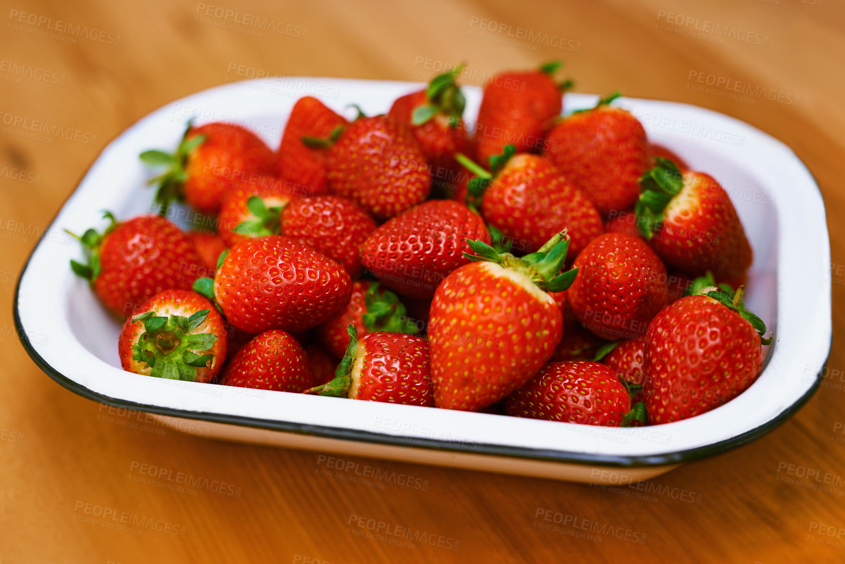 Buy stock photo Fruit, food and strawberry bowl in kitchen of home, on wooden counter top for diet or nutrition. Health, wellness and lose weight with berries on surface in apartment for detox, minerals or vitamins