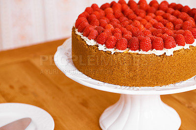 Buy stock photo Stand, cream and cheesecake with raspberries on table for sweet snack for tea time at home. Bakery, catering and closeup of gourmet dessert with crust, frosting and fresh organic fruit in dining room