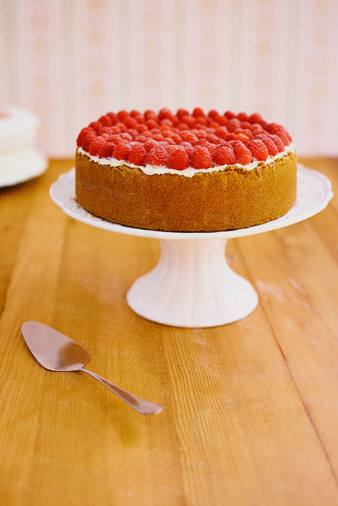 Buy stock photo Stand, spoon and cheesecake with cream and raspberries on table for sweet snack for tea time at home. Bakery, catering and gourmet dessert with crust, frosting and fresh organic fruit in dining room.