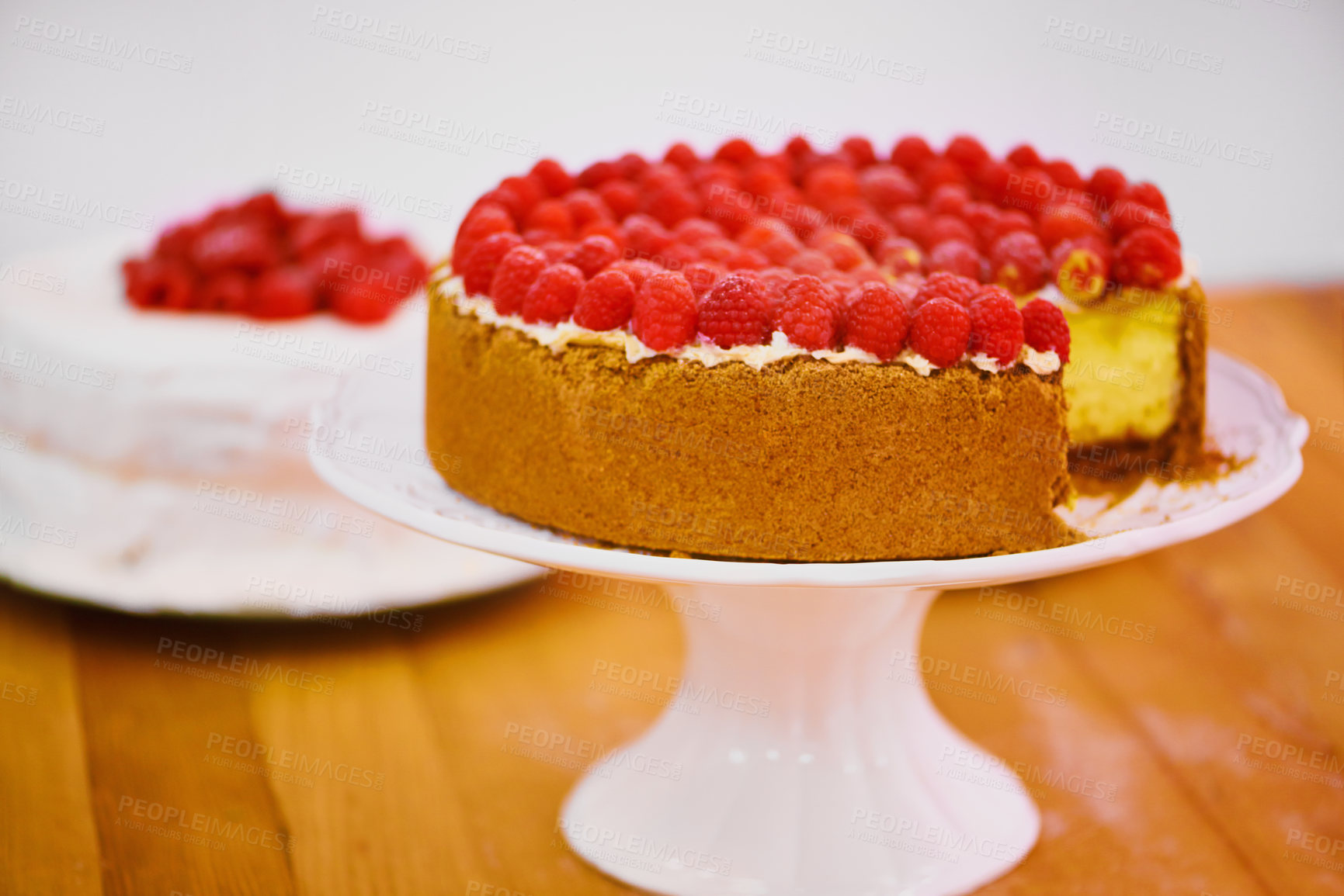 Buy stock photo Stand, slice and cheesecake with cream and raspberries on table for sweet snack for tea time at home. Bakery, catering and gourmet dessert with crust, frosting and fresh organic fruit in dining room.