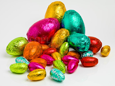 Buy stock photo Studio shot of a dazzling array of multicolored easter eggs wrapped in foil