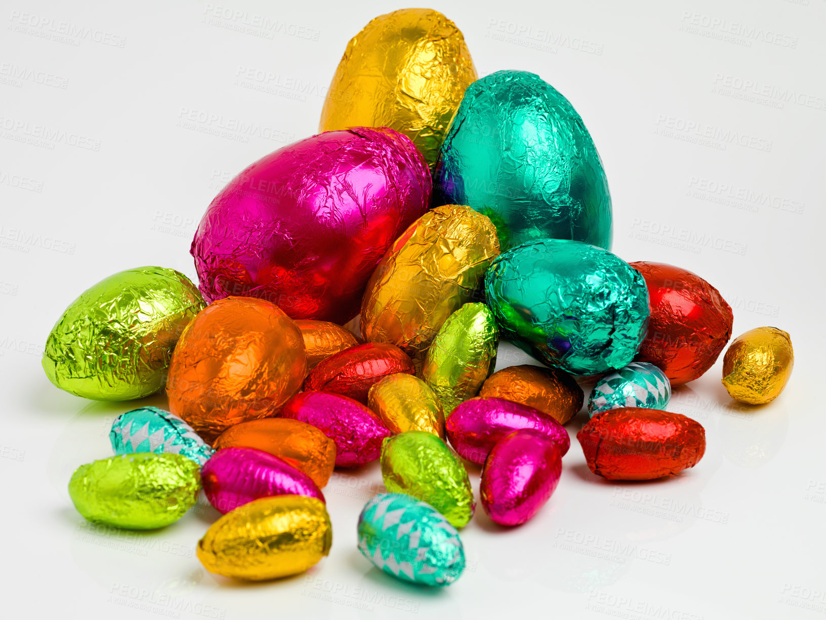 Buy stock photo Studio shot of a dazzling array of multicolored easter eggs wrapped in foil