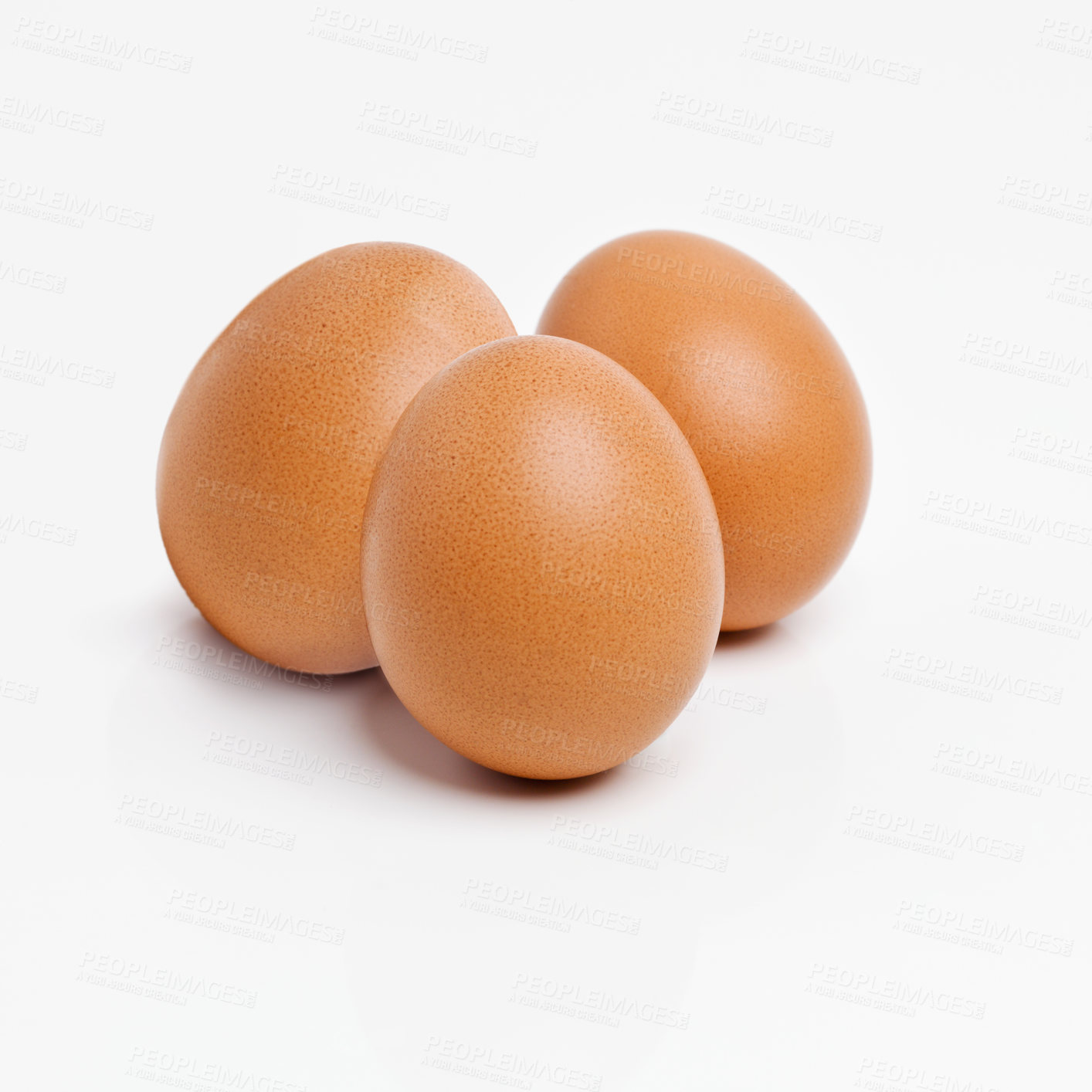 Buy stock photo Studio shot of three brown eggs isolated on white