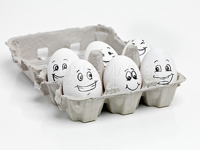 Buy stock photo Studio shot of faces drawn onto a carton of eggs