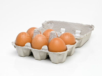 Buy stock photo Studio shot of half a dozen brown eggs in a carton