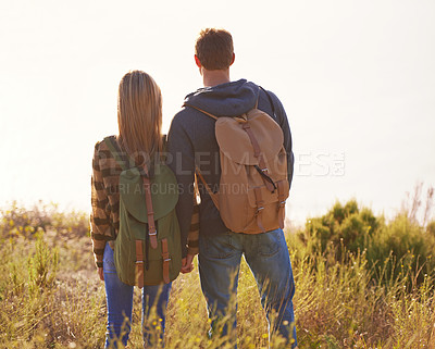 Buy stock photo Hiking, couple and holding hands in nature for holiday, travel or adventure outdoor with backpack. Rear view, man and woman trekking in the countryside on vacation, journey or date together on mockup
