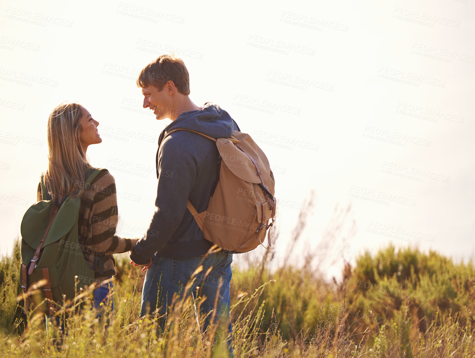 Buy stock photo Love, holding hands and couple hiking in nature for travel, backpack or communication while bonding. Happy, adventure or people speaking in countryside for field trip, vacation or exploration journey