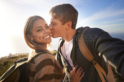 Buy stock photo Kiss, hiking and fitness couple with selfie in nature for bonding, fun or romantic memory at sunset. Happy, love and people embrace for profile picture, photography or social media travel blog photo