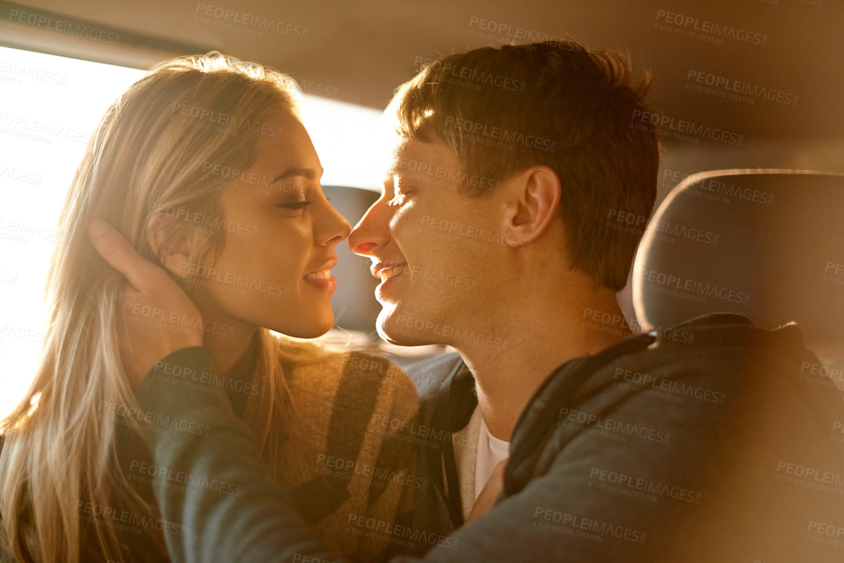 Buy stock photo Shot of an affectionate young couple about to kiss in a car
