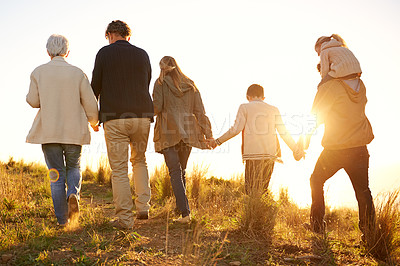 Buy stock photo Shot of a happy family holding hands on a morning walk together