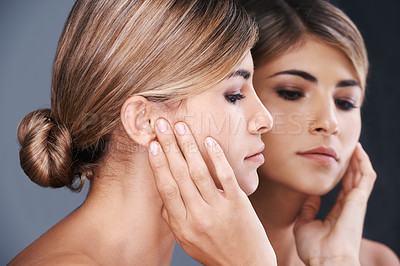 Buy stock photo Beauty, facial and mirror with natural woman in studio isolated on blue background for wellness. Aesthetic, face and skincare with reflection of confident young model at spa for cosmetic dermatology